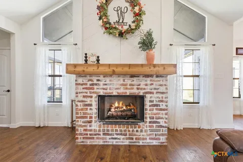 a living room with a fireplace and wooden floor
