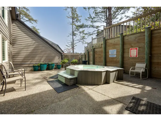 a view of a patio with table and chairs with wooden fence