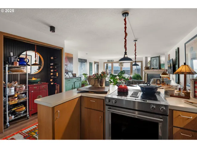 a kitchen with stainless steel appliances granite countertop a sink a stove and a wooden floors
