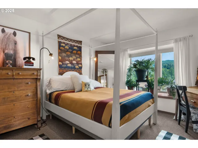 a bedroom with a bed and large windows