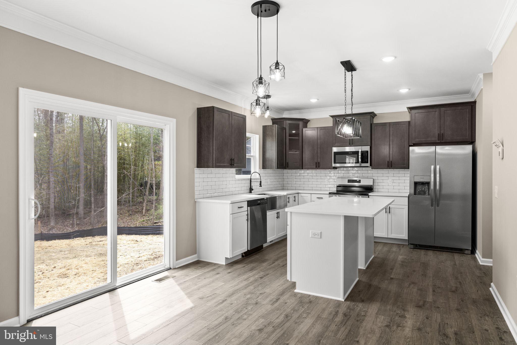 12413 Toll House Road Spotsylvania, VA 22551 - Photo 19 of 68 a kitchen with stainless steel appliances kitchen island granite countertop a refrigerator a sink dishwasher a oven with a dining table and chairs