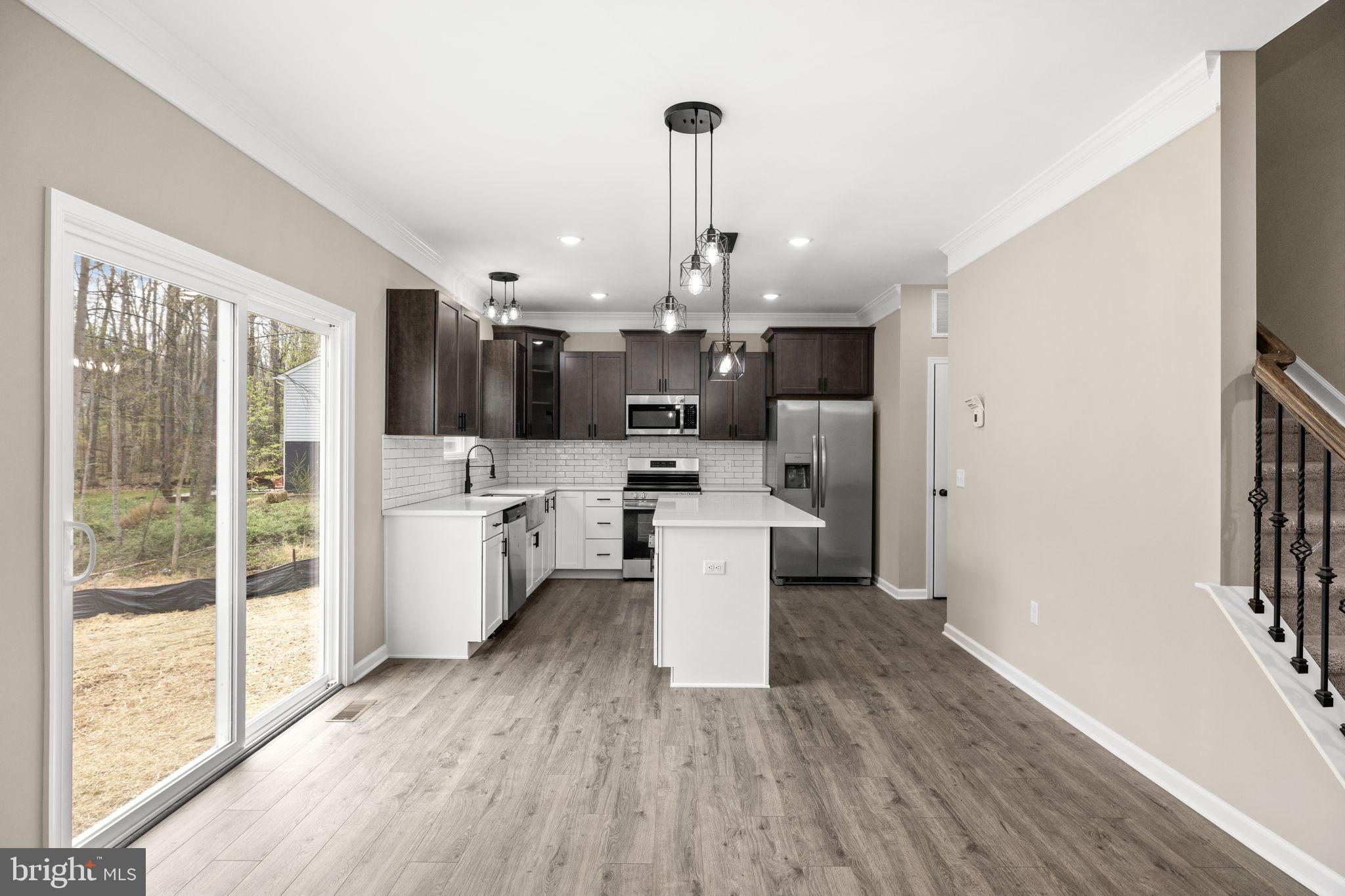 12413 Toll House Road Spotsylvania, VA 22551 - Photo 20 of 68 a view of a kitchen with a sink and dishwasher a refrigerator with wooden floor