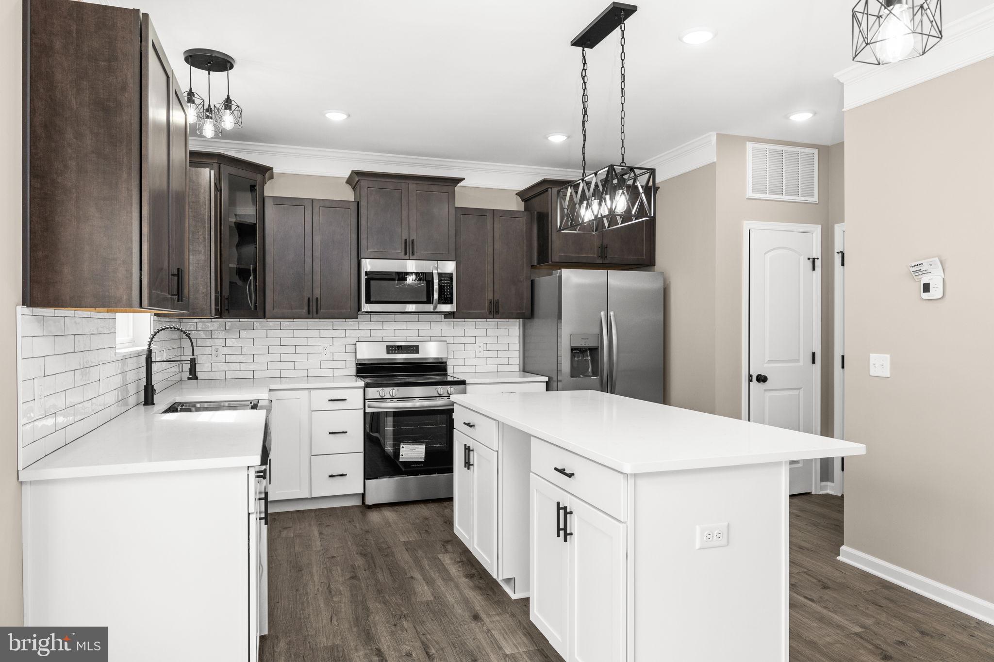 12413 Toll House Road Spotsylvania, VA 22551 - Photo 21 of 68 a kitchen that has a sink a stove top oven a refrigerator cabinets a dining table and chairs