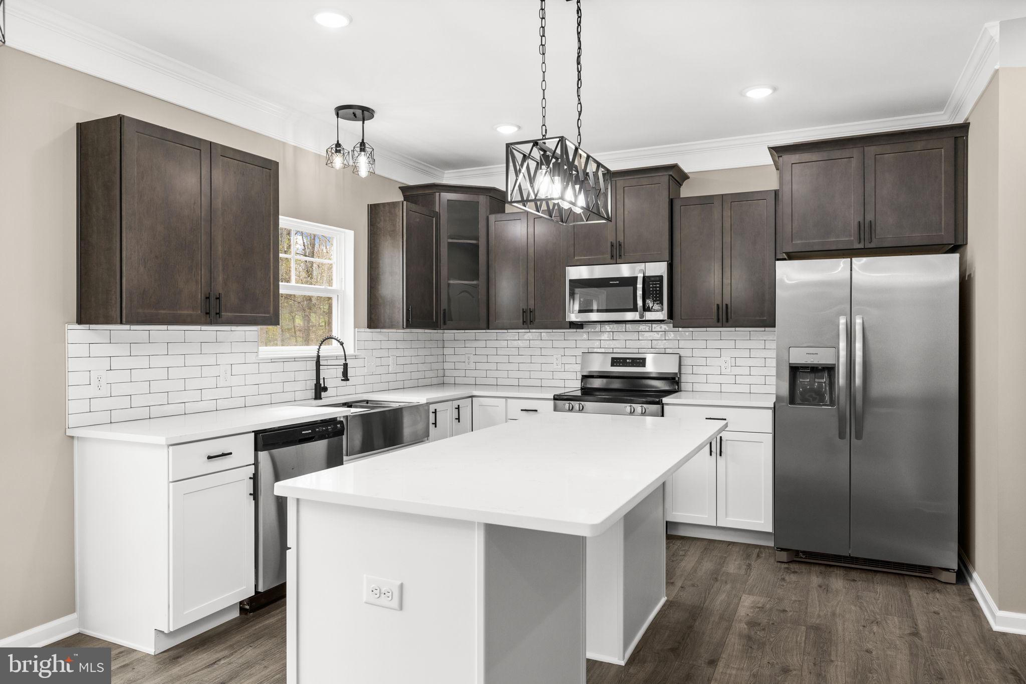 12413 Toll House Road Spotsylvania, VA 22551 - Photo 23 of 68 a kitchen with a sink a kitchen island stainless steel appliances cabinets and a counter top space