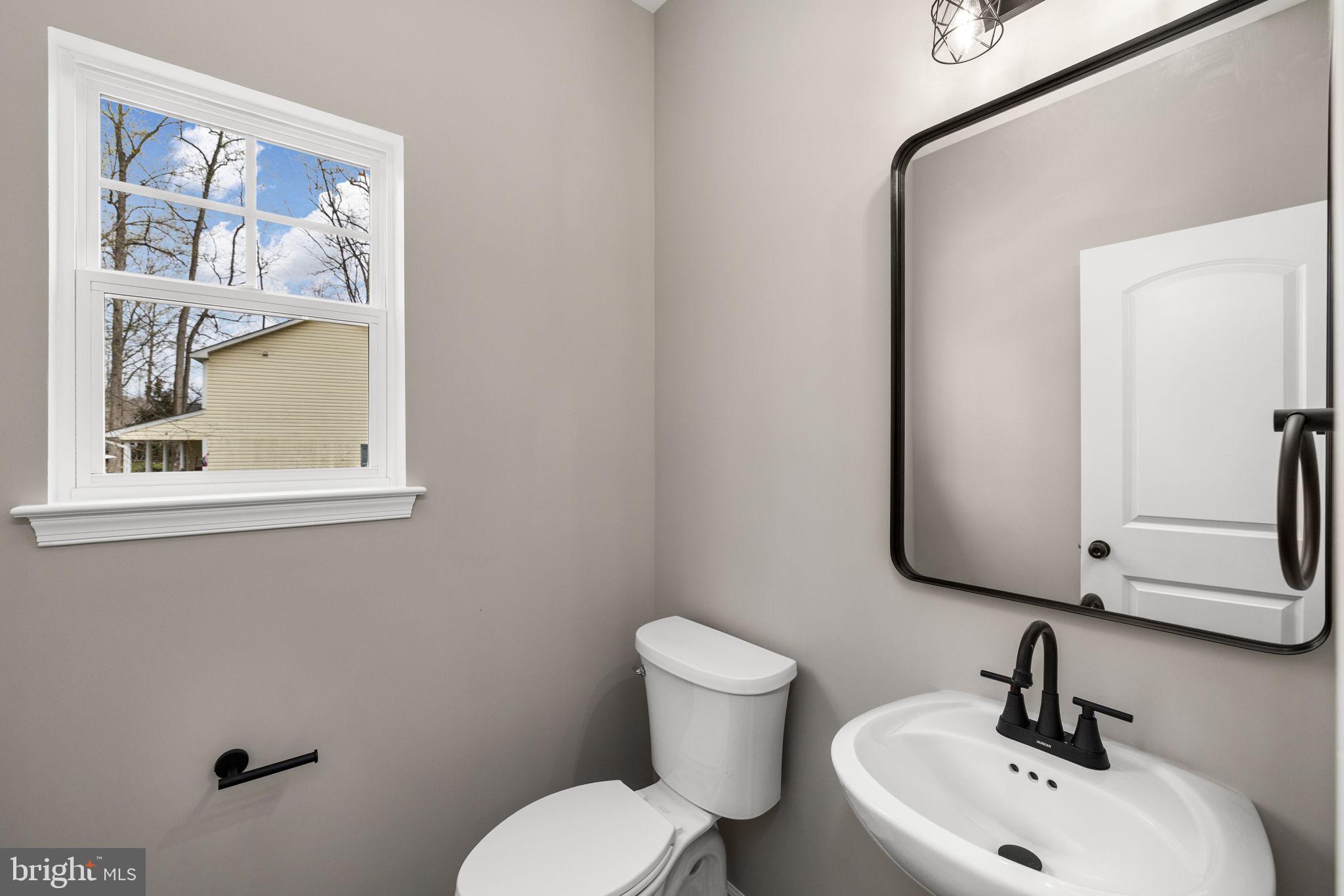 12413 Toll House Road Spotsylvania, VA 22551 - Photo 10 of 68 a bathroom with a toilet sink and mirror