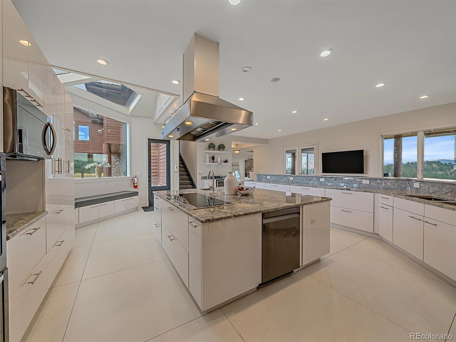 4213 Nambe Road Indian Hills, CO 80454 - Photo 14 of 49 a large kitchen with stainless steel appliances kitchen island granite countertop a sink and cabinets