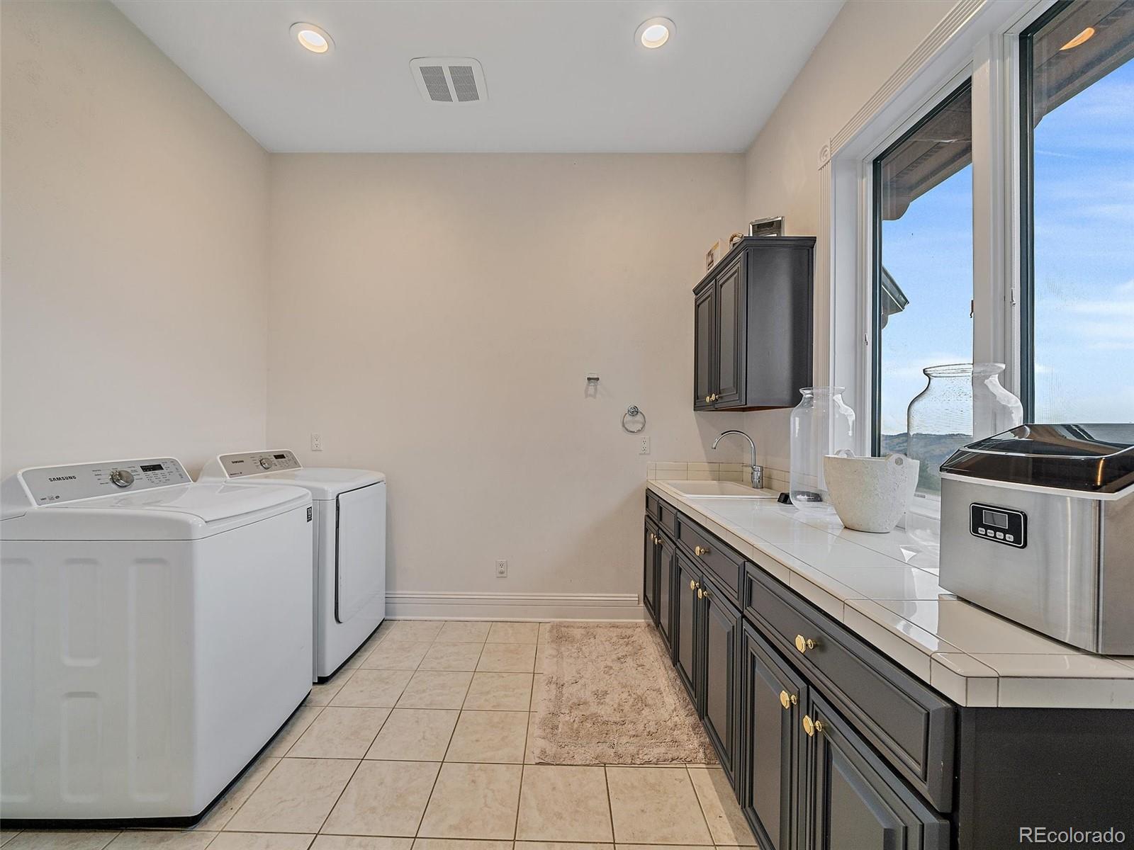 4213 Nambe Road Indian Hills, CO 80454 - Photo 19 of 49 a utility room with cabinets washer and dryer