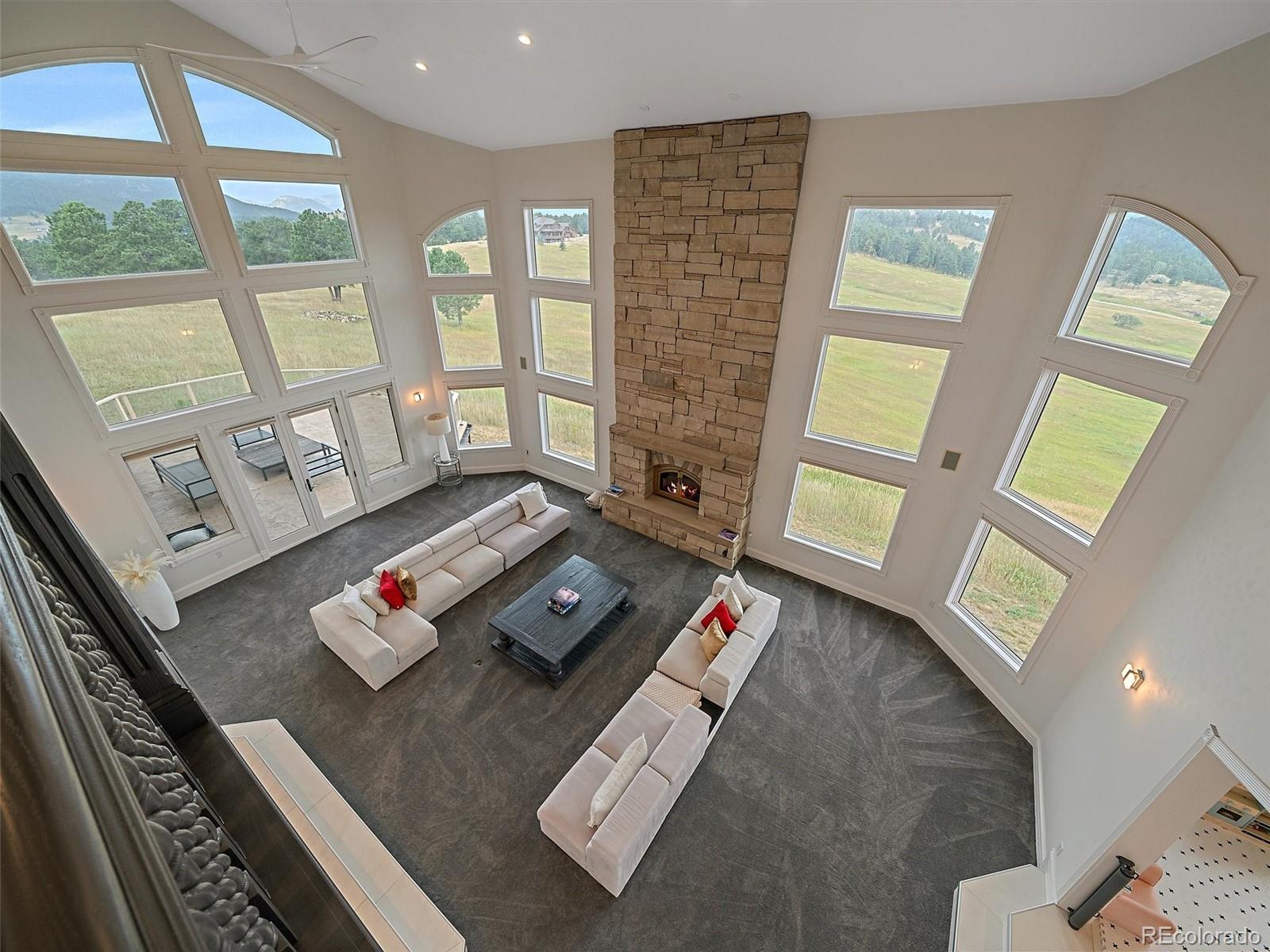 4213 Nambe Road Indian Hills, CO 80454 - Photo 23 of 49 a living room with furniture and a floor to ceiling window