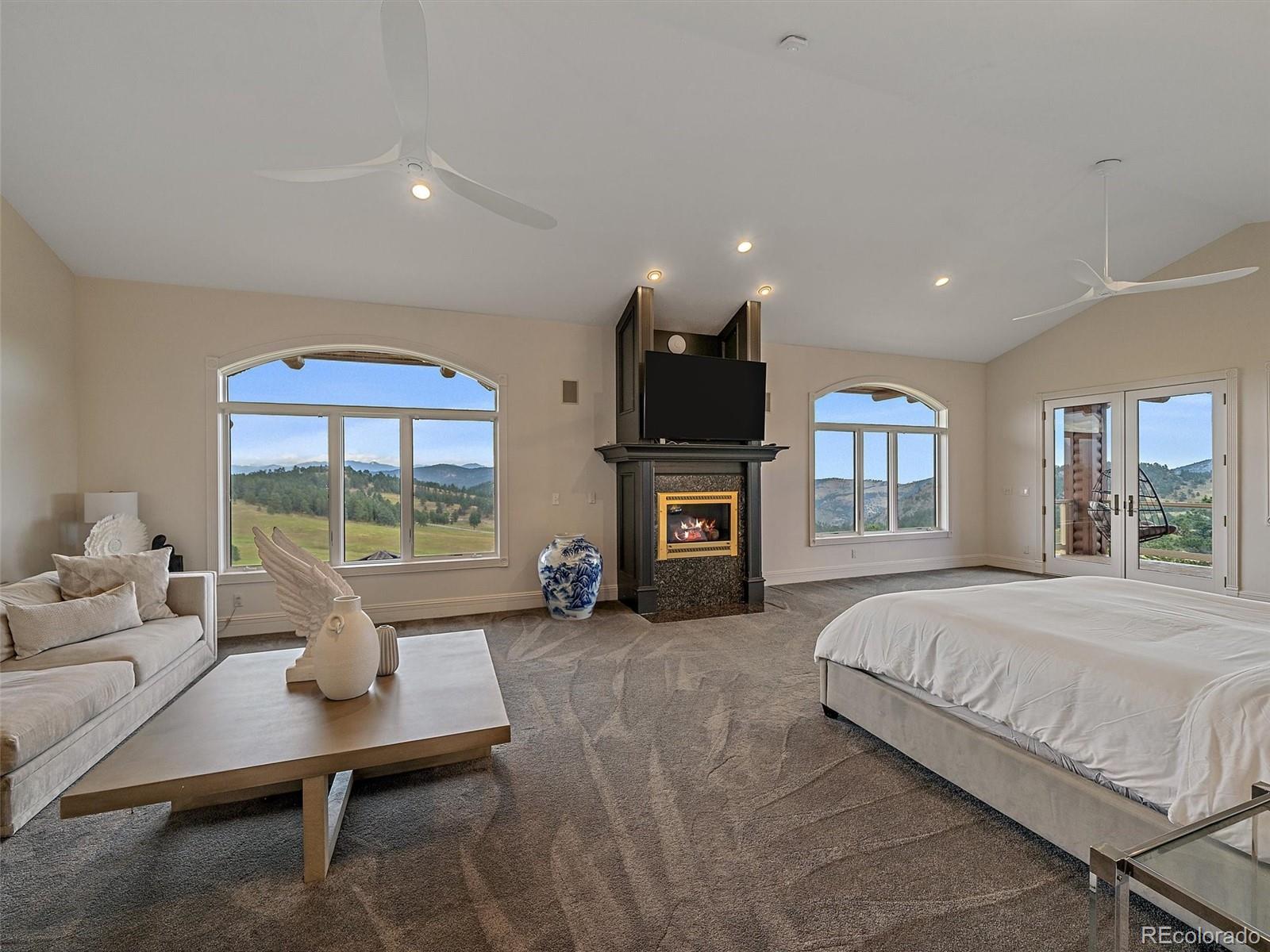 4213 Nambe Road Indian Hills, CO 80454 - Photo 24 of 49 a spacious bedroom with a bed and large windows