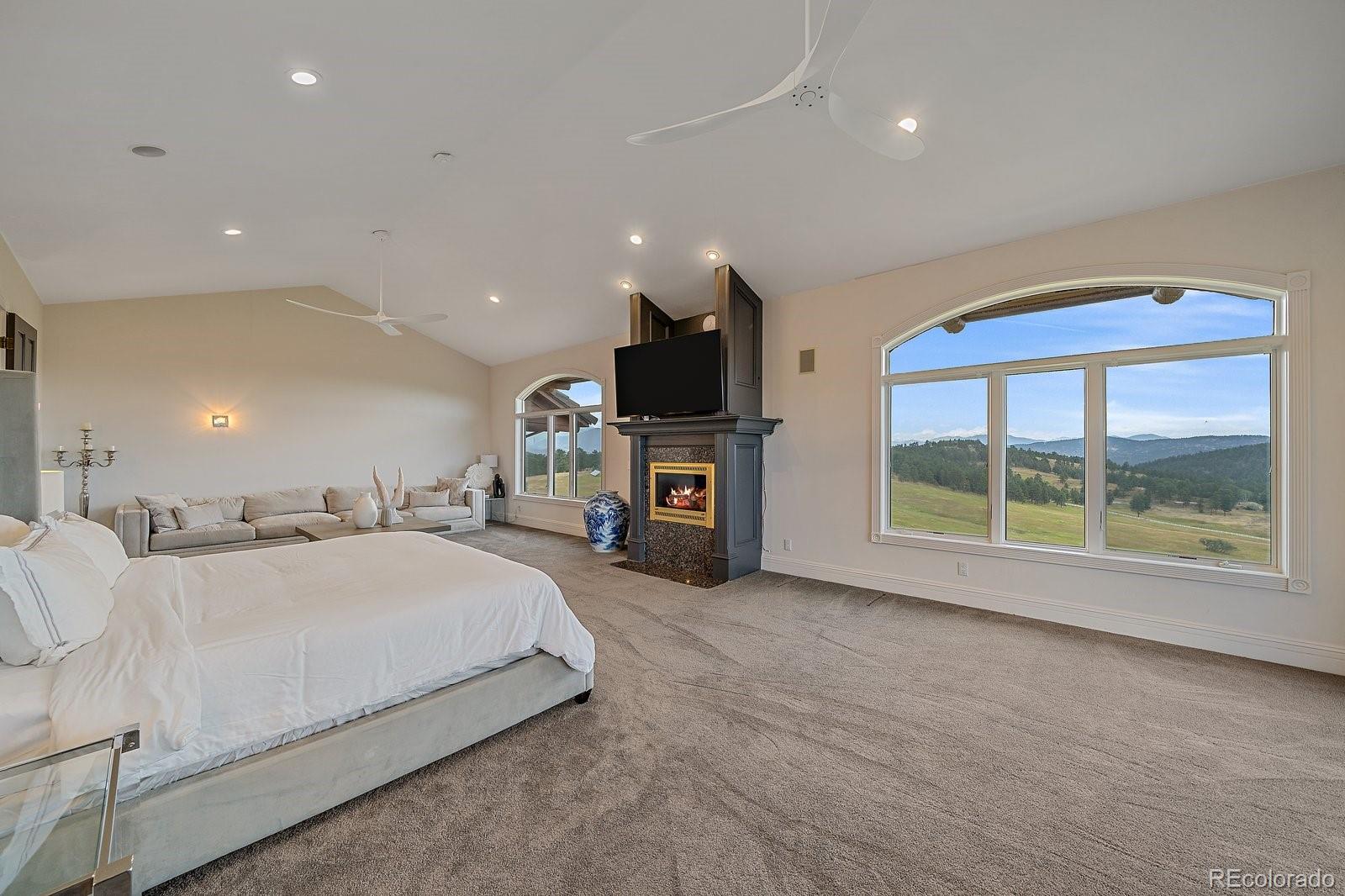 4213 Nambe Road Indian Hills, CO 80454 - Photo 25 of 49 a spacious bedroom with a large bed and a large window