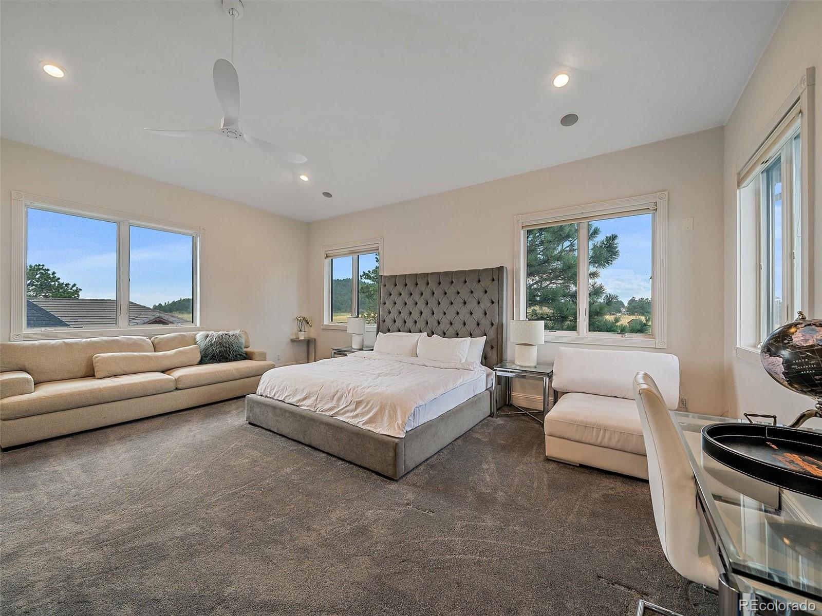4213 Nambe Road Indian Hills, CO 80454 - Photo 33 of 49 a spacious bedroom with a bed and glass window