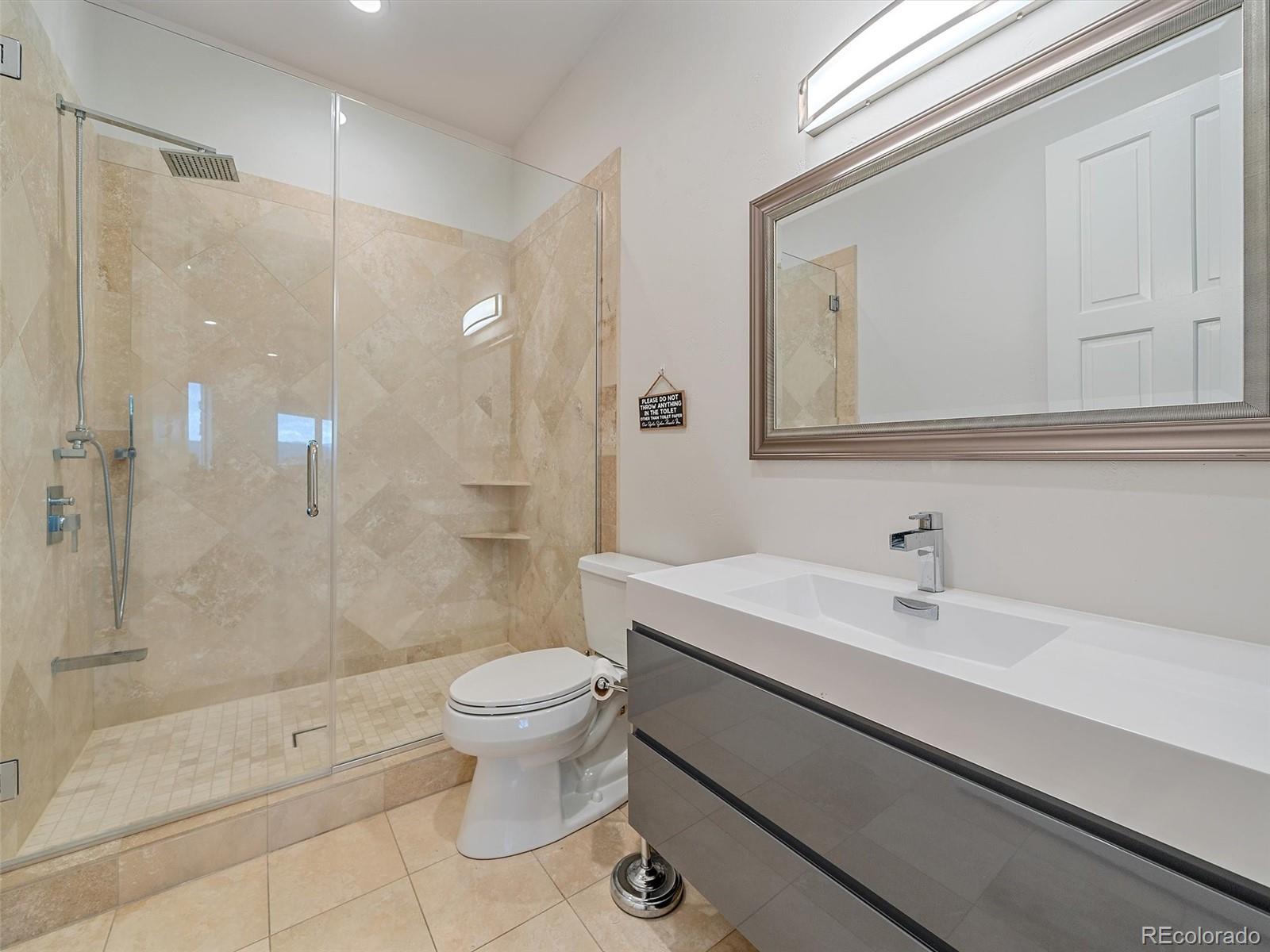 4213 Nambe Road Indian Hills, CO 80454 - Photo 43 of 49 a bathroom with a sink a toilet and shower