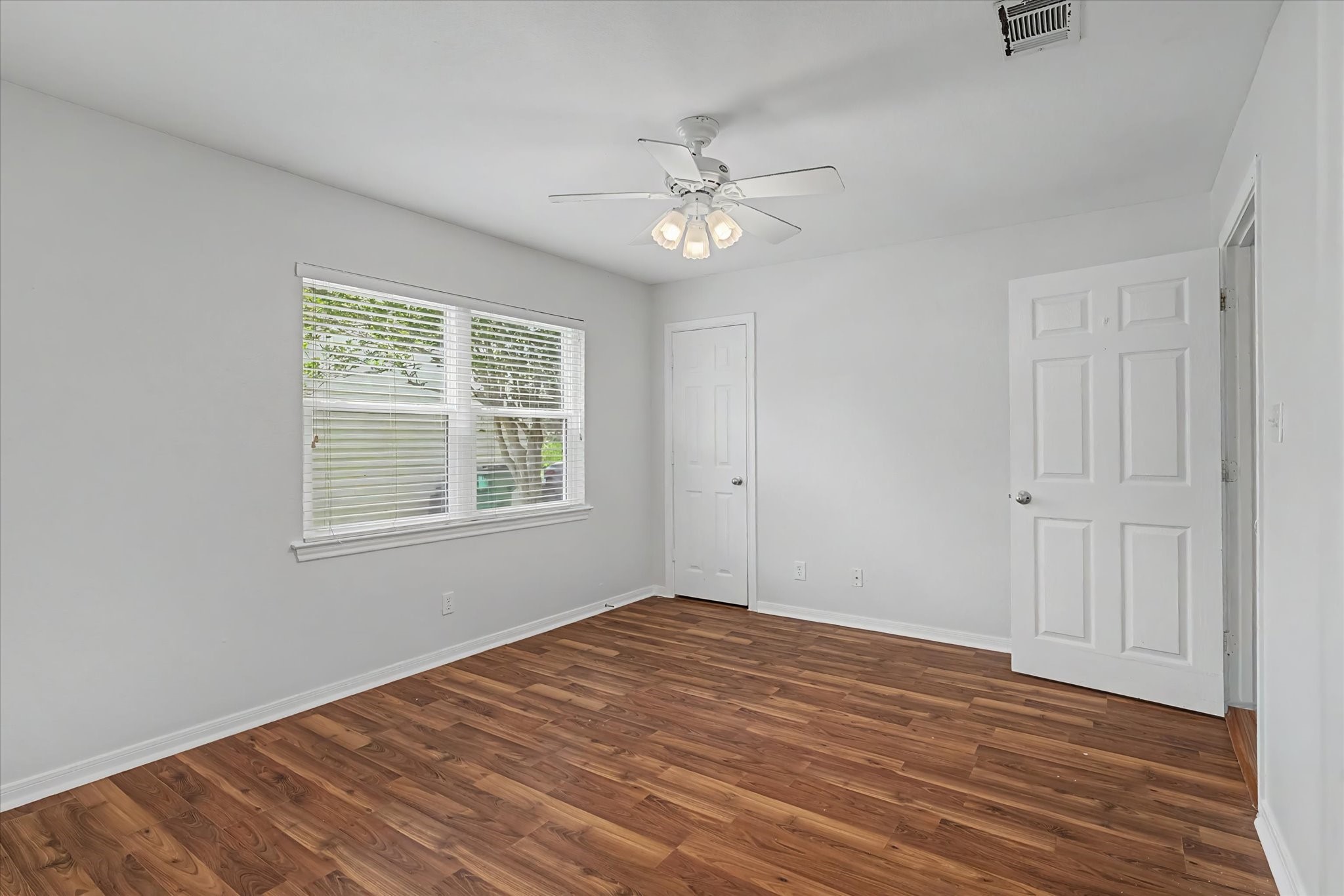 413 Farrer Street Angleton, TX 77515 - Photo 35 of 43 a view of an empty room with wooden floor and a window