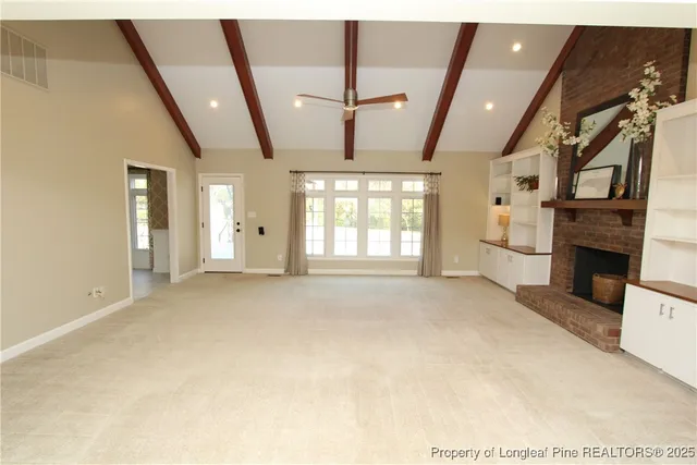 a view of an empty room with a fireplace and a window