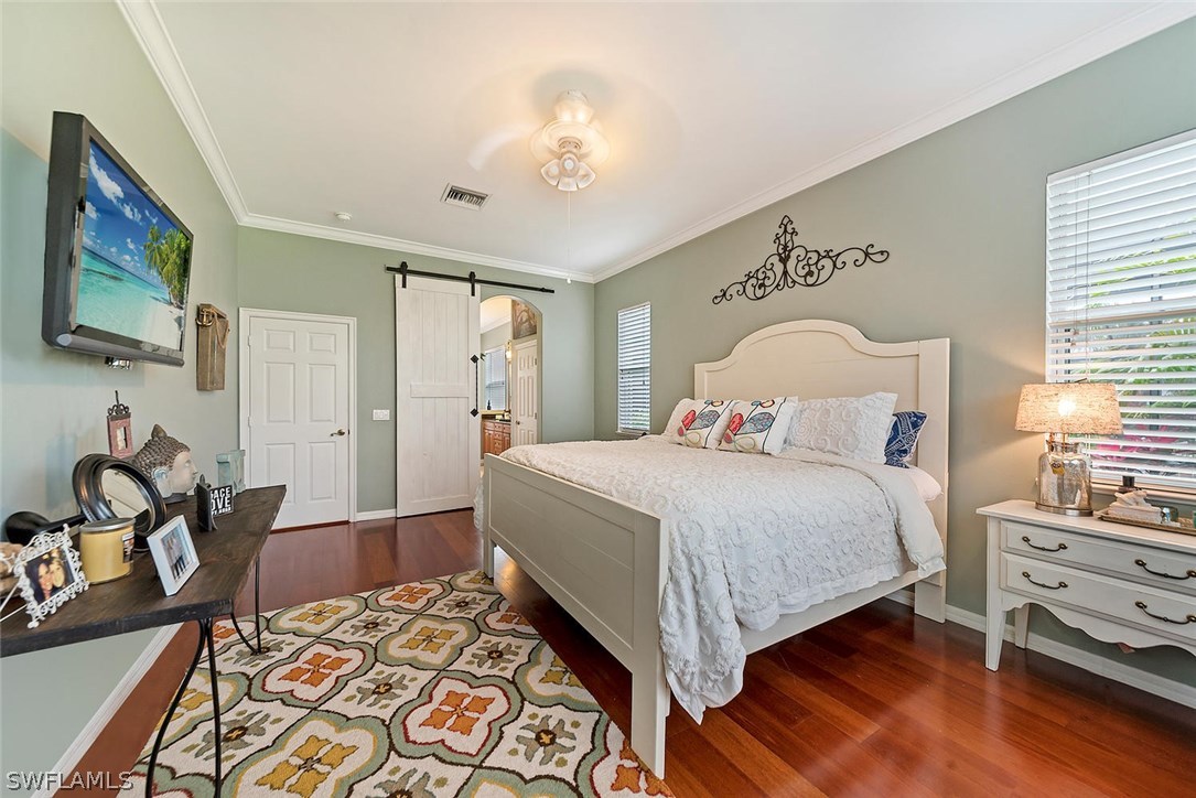 12941 Timber Ridge Drive Fort Myers, FL 33913 - Photo 16 of 30 a bedroom with a bed and wooden floor
