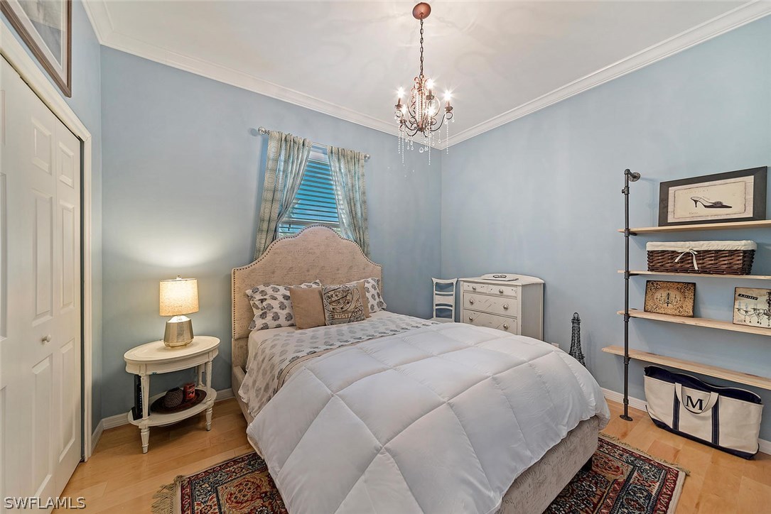 12941 Timber Ridge Drive Fort Myers, FL 33913 - Photo 18 of 30 a bedroom with bed and a chandelier