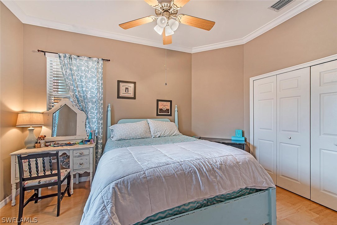 12941 Timber Ridge Drive Fort Myers, FL 33913 - Photo 20 of 30 a bedroom with a bed and a chandelier