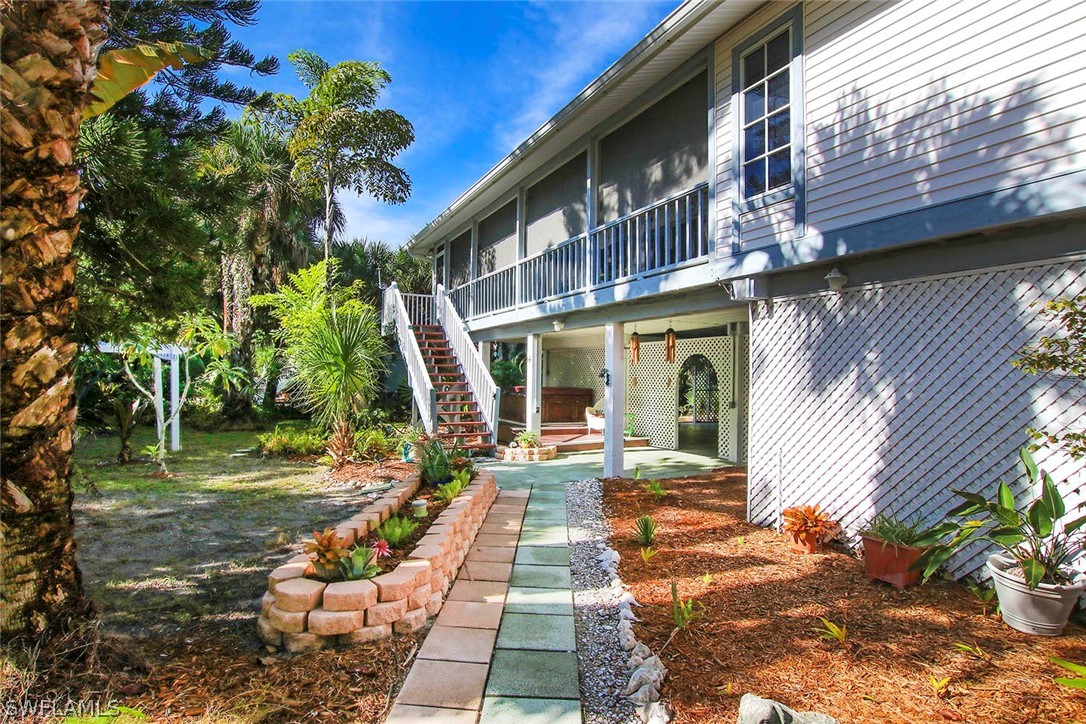 555 Rabbit Road Sanibel, FL 33957 - Photo 1 of 29 a front view of a house with garden