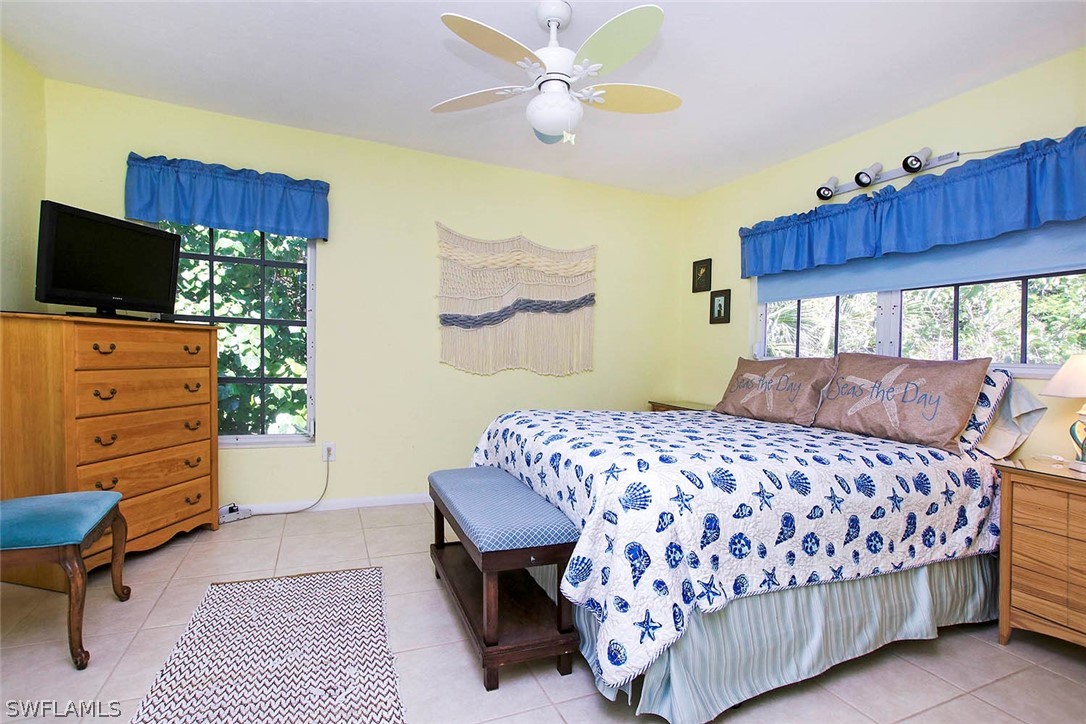 555 Rabbit Road Sanibel, FL 33957 - Photo 13 of 29 a bedroom with a bed and wooden floor