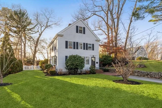 a front view of a house with a yard and trees
