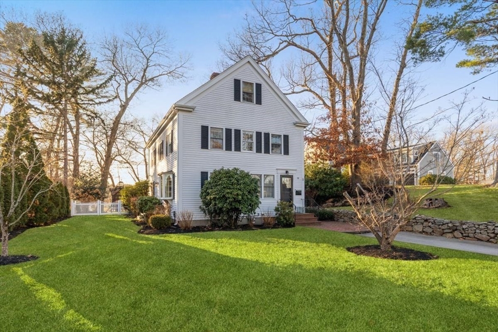 a front view of a house with a yard and trees