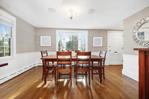 a view of a a dining room with furniture window and wooden floor