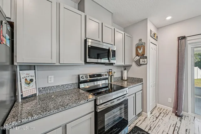 a kitchen with stainless steel appliances granite countertop a sink stove and microwave