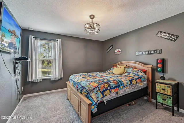 a bedroom with a bed and a chandelier