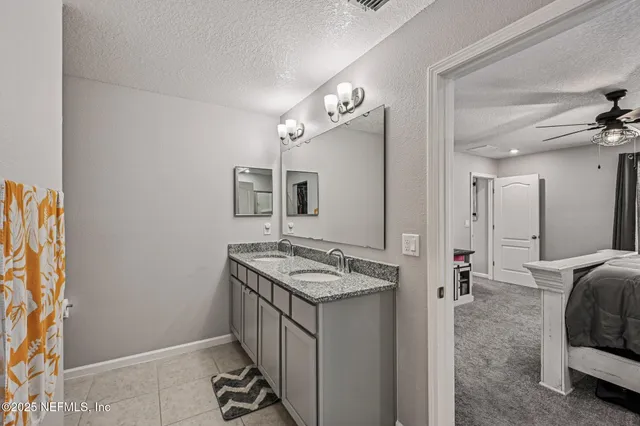 a en suite bathroom with a granite countertop sink and a mirror