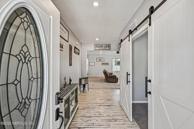a view of a hallway with wooden floor and staircase