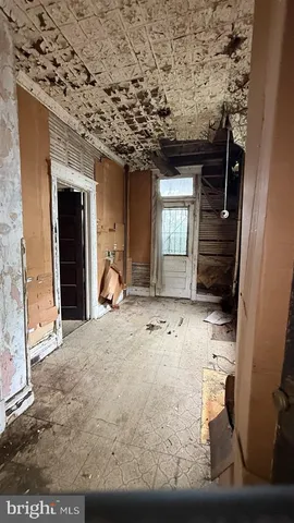 an empty room with windows and fireplace