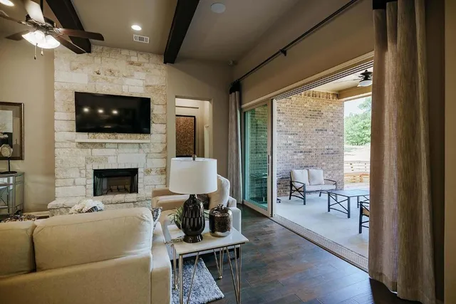 a living room with furniture a flat screen tv and a fireplace