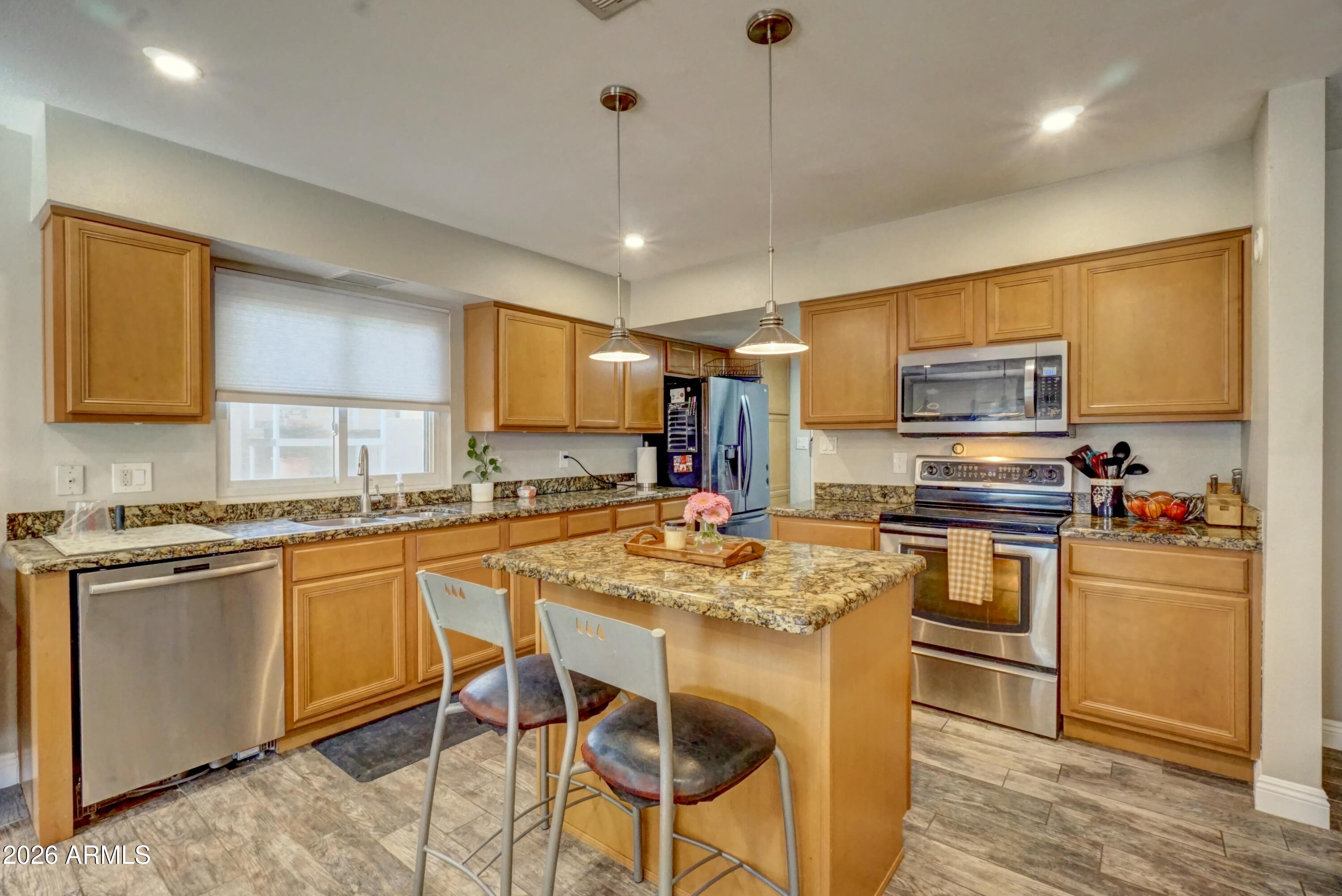 2749 East Sylvia Street Phoenix, AZ 85032 - Photo 12 of 44 a kitchen with stainless steel appliances granite countertop a stove top oven a granite counter tops and white cabinets