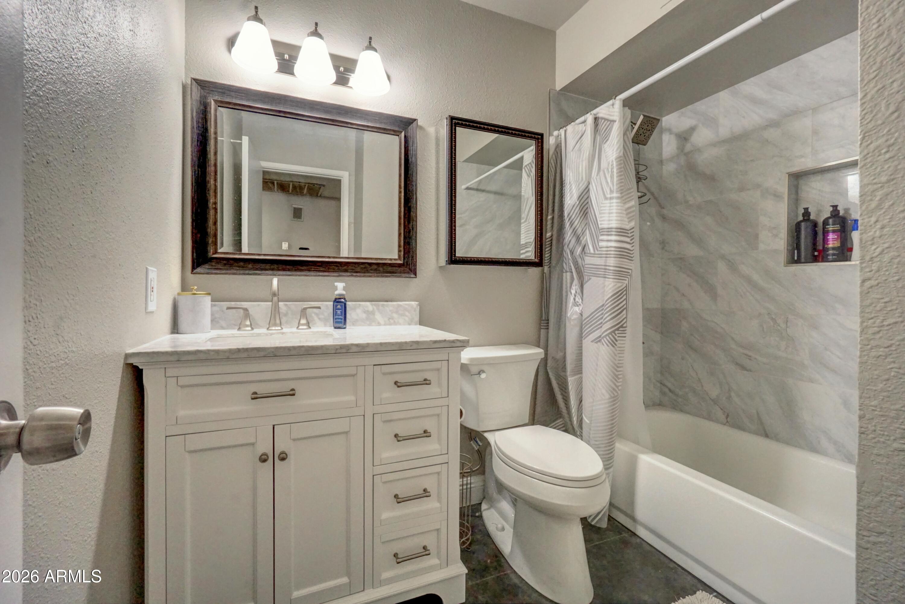 2749 East Sylvia Street Phoenix, AZ 85032 - Photo 25 of 44 a bathroom with a toilet a sink a mirror a bathtub and vanity