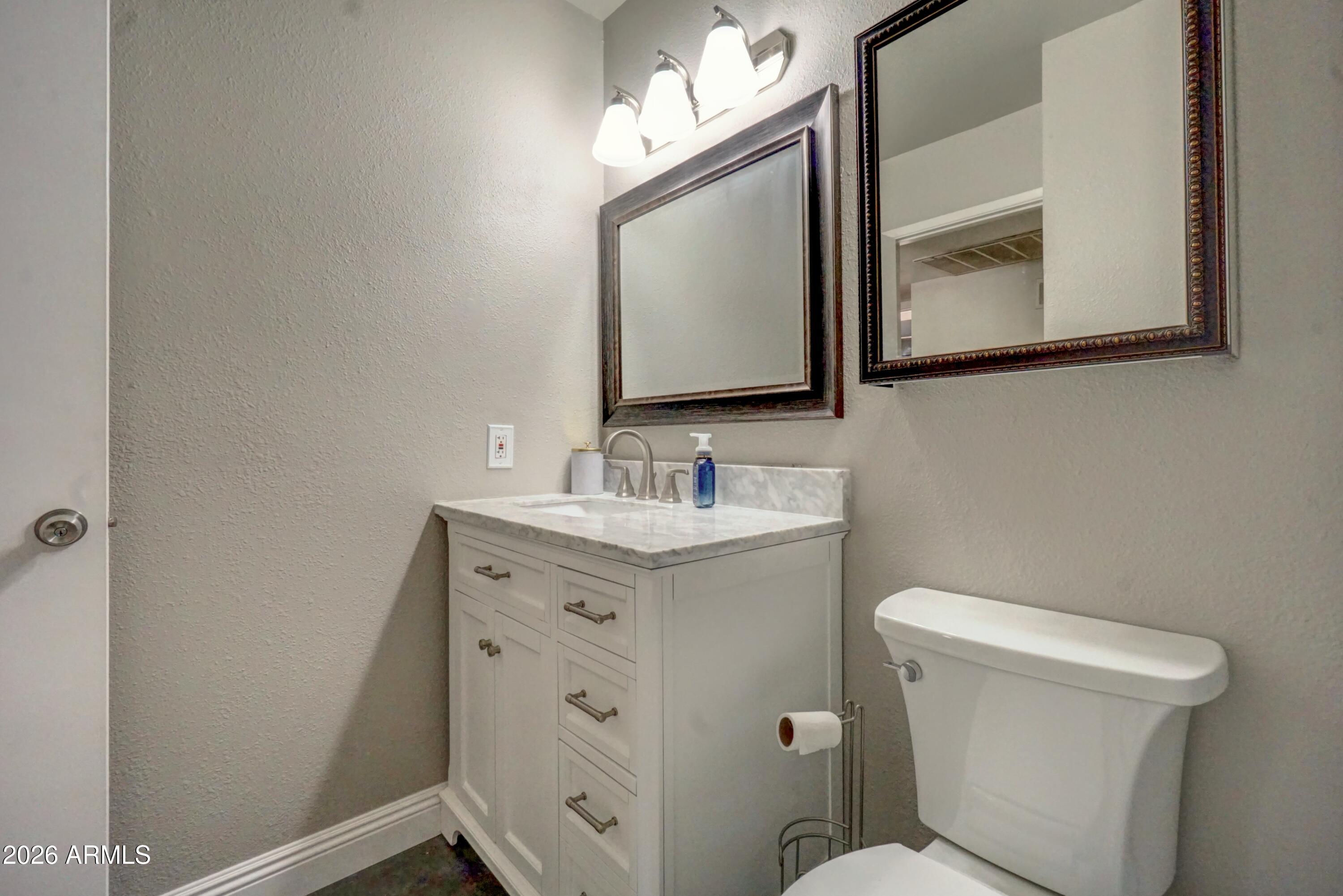 2749 East Sylvia Street Phoenix, AZ 85032 - Photo 26 of 44 a bathroom with a toilet sink and mirror