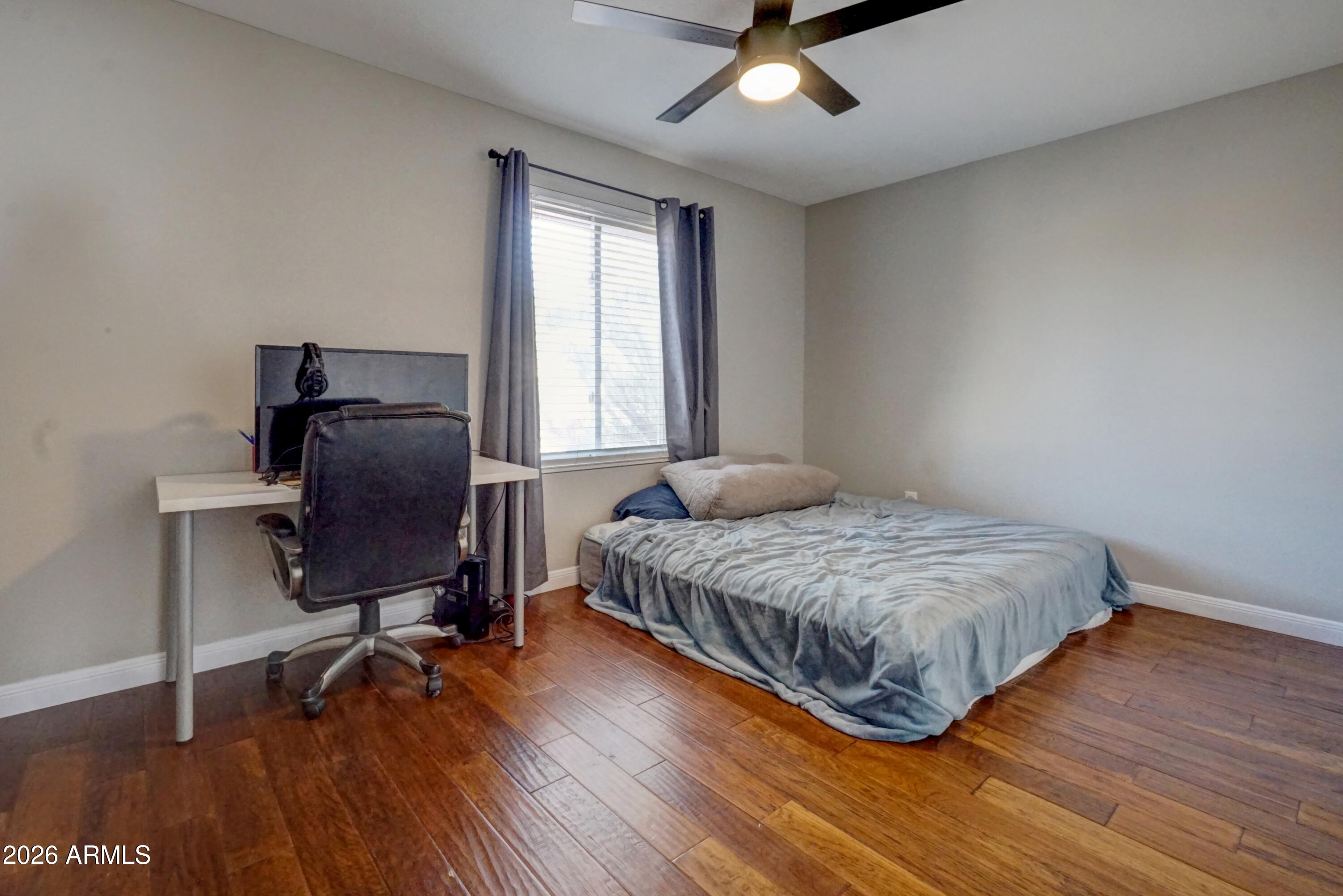 2749 East Sylvia Street Phoenix, AZ 85032 - Photo 27 of 44 a bedroom with a bed and wooden floor