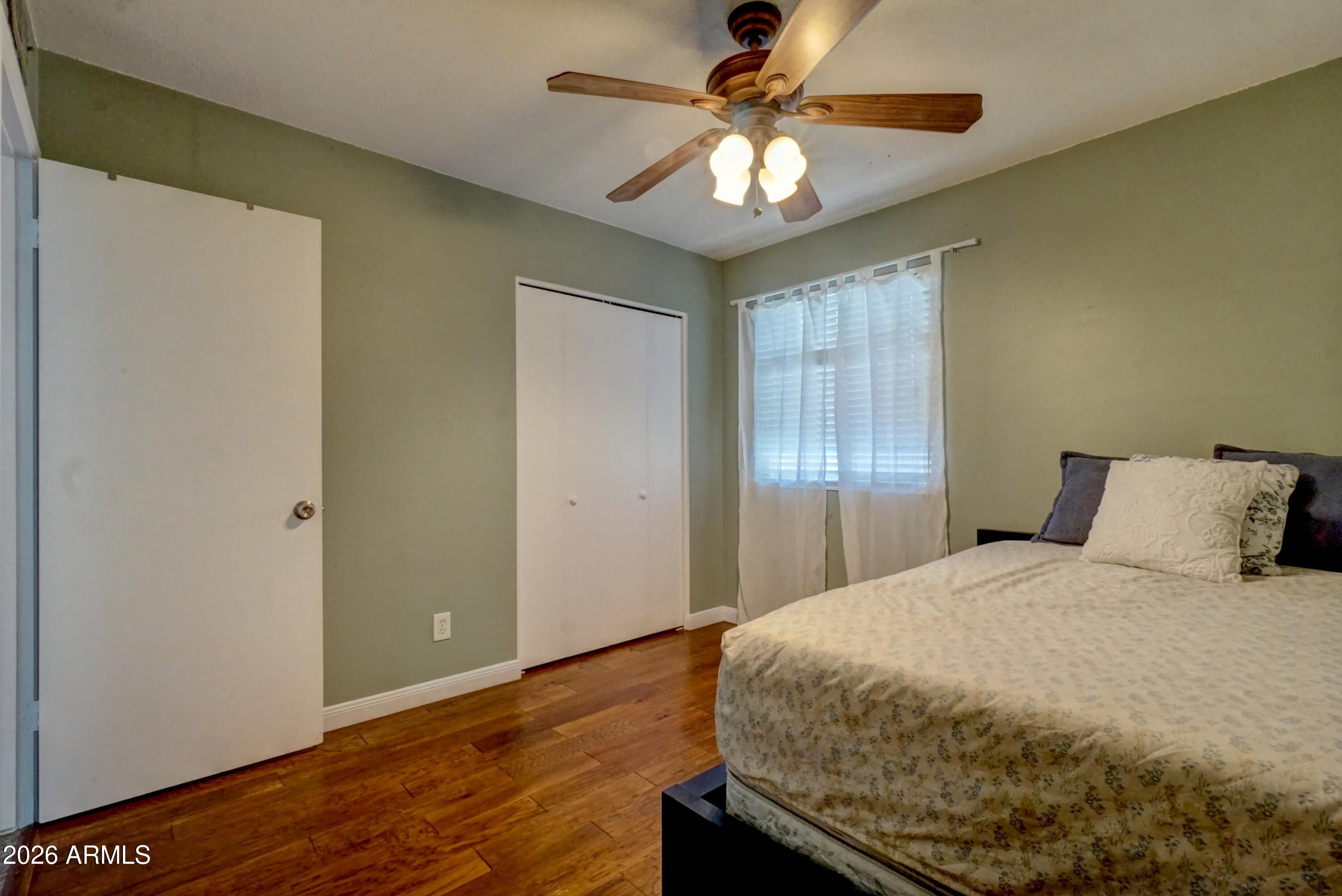 2749 East Sylvia Street Phoenix, AZ 85032 - Photo 30 of 44 a bedroom with a bed and wooden floor