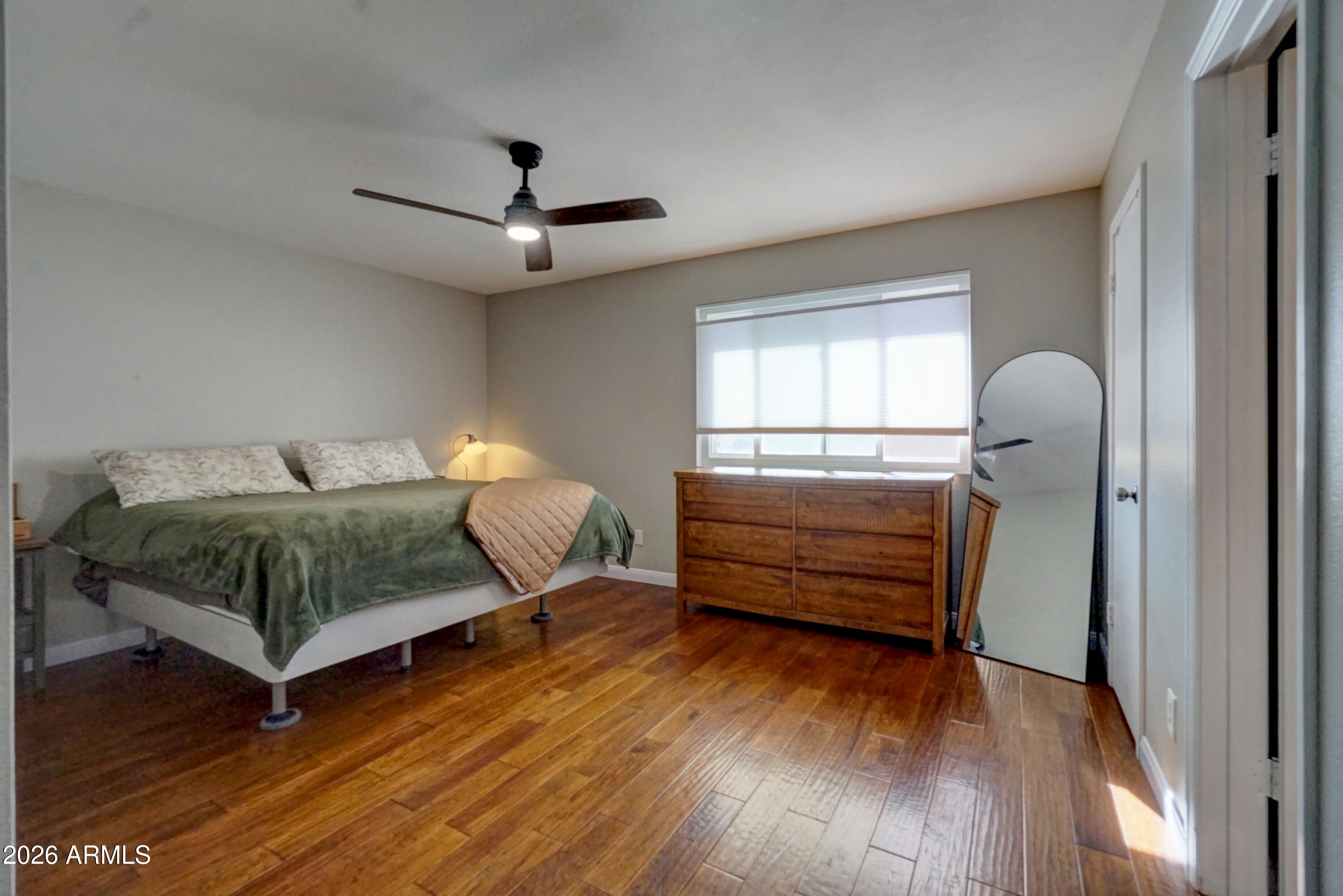 2749 East Sylvia Street Phoenix, AZ 85032 - Photo 31 of 44 a bedroom with a bed and wooden floor