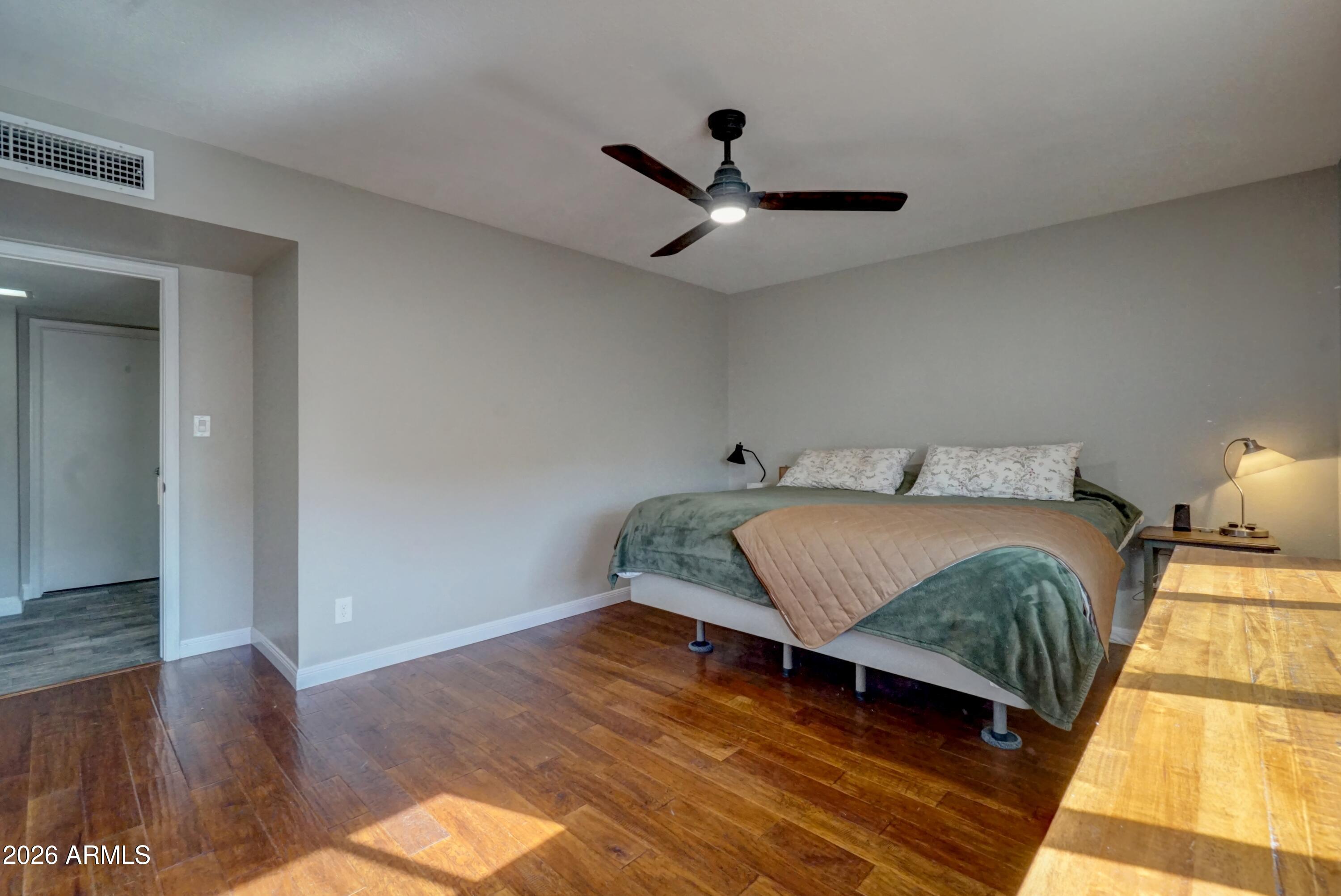 2749 East Sylvia Street Phoenix, AZ 85032 - Photo 32 of 44 a bedroom with a bed and wooden floor