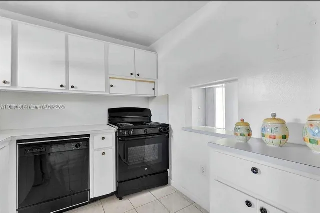 a kitchen with white cabinets and appliances