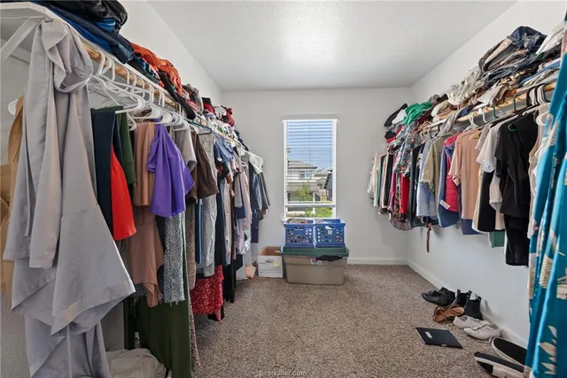 a view of walk in closet with clothes