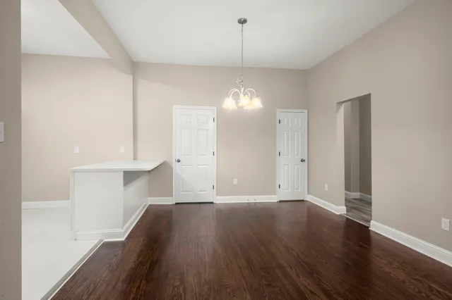 a view of a room with wooden floor and cabinets