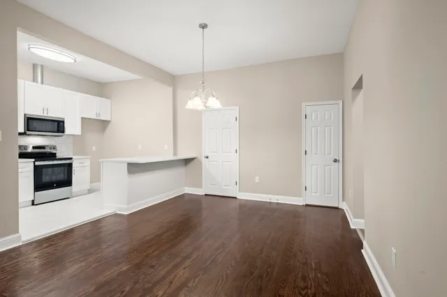 wooden floor in an empty room with a kitchen
