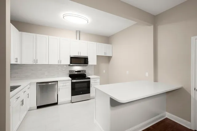 a kitchen with granite countertop white cabinets and white appliances