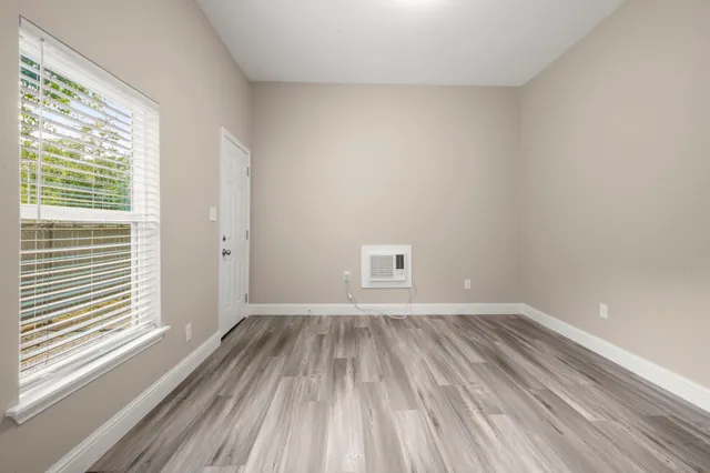 a view of a room with wooden floor and a window