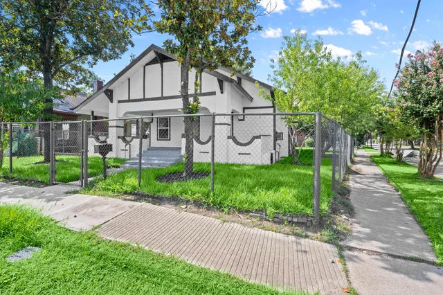 a view of a big house with a big yard and large trees