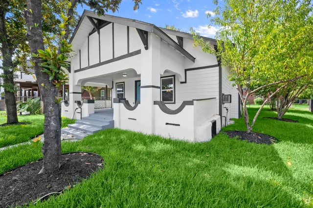 a white house that has tree in front of it