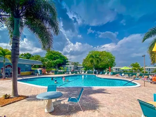 a view of a park with plants and palm trees