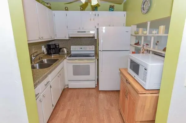 a kitchen with a white stove top oven and refrigerator