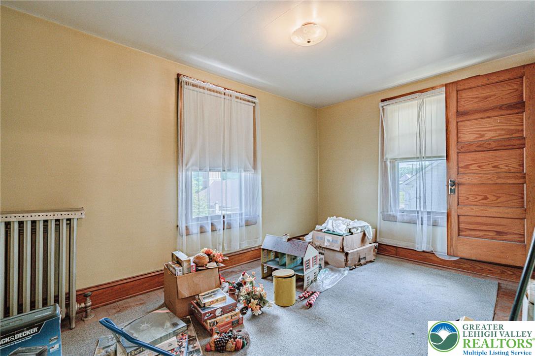 159 West Ridge Street Nesquehoning, PA 18240 - Photo 27 of 55 A quiet, carpeted room awaiting your personal touch, featuring warm wooden trim and natural light.
